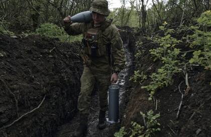 Un soldado ucraniano lleva proyectiles de cañón en una trinchera cerca de Bakhmut, una ciudad oriental donde se han producido feroces batallas contra las fuerzas rusas, en la región de Donetsk, Ucrania, el sábado 29 de abril de 2023.