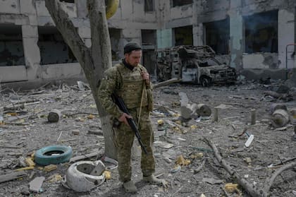 Un soldado ucraniano se para frente a una escuela alcanzada por cohetes rusos en la aldea de Zelenyi Hai, en el sur de Ucrania, entre Kherson y Mykolaiv, a menos de 5 km de la línea del frente el 1 de abril de 2022