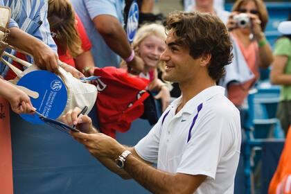Un sonriente Roger Federer firma autógrafos de sus muchos fanáticos después de su 50º título ATP de su carrera después de derrotar a James Blake (EE. UU.) en el partido de campeonato en el torneo de tenis Masters ATP del Western and Southern Financial Group en Cincinnati