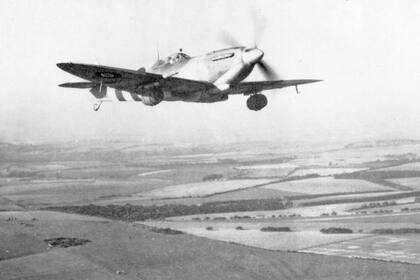 Un Spitfire Mk IX parte de la base aérea de Tagmere, en Sussex, con barriles de cerveza bajo sus alas