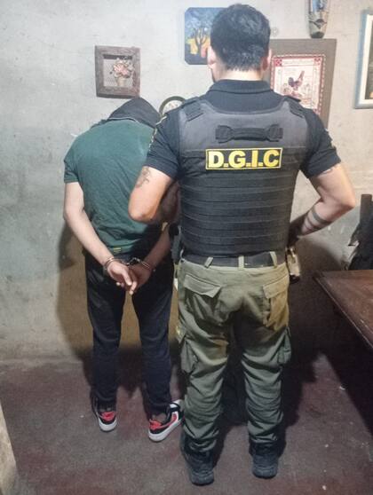 Un tercer sospechoso permanece esposado mientras es identificado por personal de la Dirección General de Investigaciones Criminales tras los allanamientos