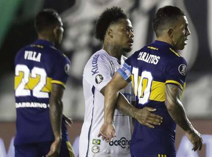 Un Tevez decepcionado recibe el saludo y consuelo de Marinho, la figura en la goleada de Santos