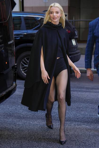 Un toque sensual en total black: crop top con pedrería y cuello alto, culotte y stilettos de Christian Louboutin bajo una de las prendas tendencia de este año: la capa.