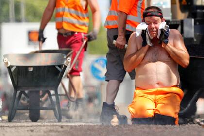Un trabajador de la construcción se limpia la cara , mientras que las temperaturas alcanzan nuevos máximos históricos en Berlín, Alemania
