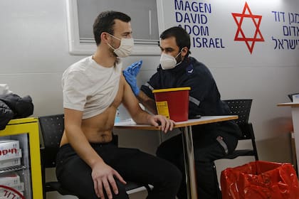 Un trabajador de la salud administra la vacuna contra el coronavirus a un israelí en una clínica móvil en la ciudad costera de Tel Aviv el 18 de febrero de 2021