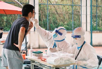 Un trabajador de la salud con equipo de protección personal realiza una prueba de hisopado para detectar el coronavirus Covid-19 