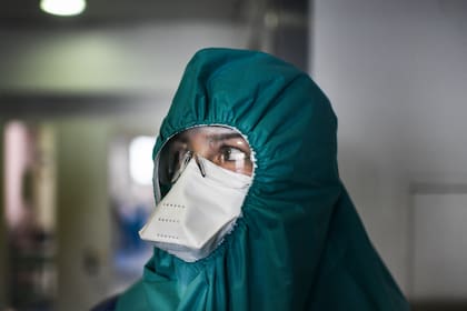 Un trabajador de la salud con un traje protector se prepara antes de ingresar a la unidad de cuidados intensivos de pacientes con Covid-19 en el Hospital de Santa María en Lisboa