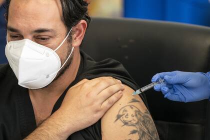 Un trabajador de la salud recibe la primera de dos inyecciones de la vacuna Pfizer/BioNTech contra el coronavirus