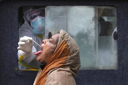 Un trabajador de la salud sentado en una ambulancia toma un hisopo para detectar la enfermedad por coronavirus (COVID-19) en Kolkata, India, el 1 de julio de 2020. REUTERS / Rupak De Chowdhuri