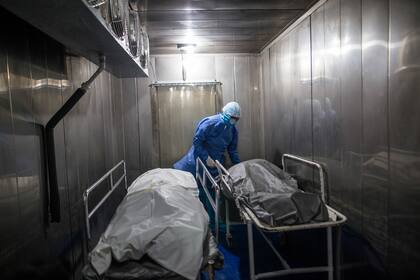 Un trabajador de la salud traslada a la morgue los cuerpos de los pacientes fallecidos por COVID-19, en el Hospital Samaritana de Bogotá, Colombia, el jueves 3 de junio de 2021.. (AP Foto/Ivan Valencia)