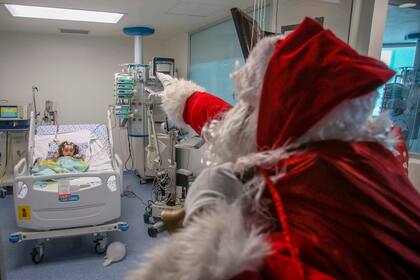 Un trabajador de la salúd vestido de Papá Noel hizo visitas solidarias en un hospital de niños, en Colombia