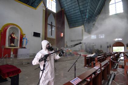 Un trabajador de salud desinfecta la Iglesia de Santa María en Palu en Java Central, Indonesia, el 23 de diciembre de 2020, antes de los servicios de Navidad