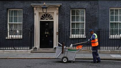 Un trabajador de Westminster limpia Downing Street a la altura de la residencia oficial de la primera ministra Theresa May; todos los ojos están puestos en qué pasará tras las elecciones