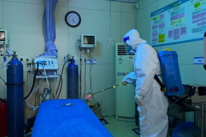 Un trabajador del hospital con equipo de protección desinfecta la sala de un departamento de emergencias del Hospital Aeroespacial de la Nueva Área de Baigou en Baigou, en la provincia de Hebei, en el norte de China, el jueves 22 de diciembre de 2022
