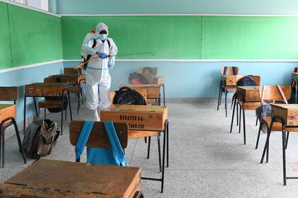 Un trabajador del Servicio de Salud Metropolitano de Nairobi desinfecta un aula en la Escuela Primaria Kongoni en Kenia el 12 de octubre de 2020, luego del cierre de escuelas en todo el país debido al brote del coronavirus