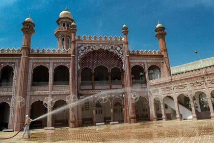 Un trabajador desinfecta una mezquita durante el mes sagrado islámico del Ramadán