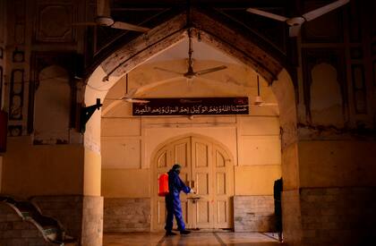Un trabajador desinfecta una mezquita en Peshawar