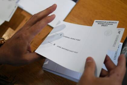 Un trabajador electoral prepara papeletas antes de la apertura de una mesa de votación durante la segunda vuelta de las elecciones presidenciales.
