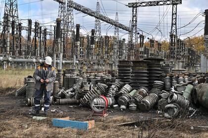 Un trabajador examina los destrozos mientras repara los equipos de las líneas eléctricas destruidas tras el ataque con misiles a una central eléctrica, en un lugar no revelado de Ucrania, el 27 de octubre de 2022, en medio de la invasión rusa de Ucrania. 