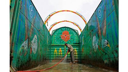 Un trabajador lava un camión decorado en Peshawar