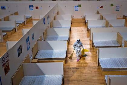 Un trabajador limpia el hospital de campaña de Wuhan que fue cerrado esta semana debido a la baja de casos de coronavirus