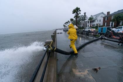 Un trabajador lleva un saco de arena en Charleston, Carolina del Sur, el viernes 29 de septiembre (Alex Brandon/AP)