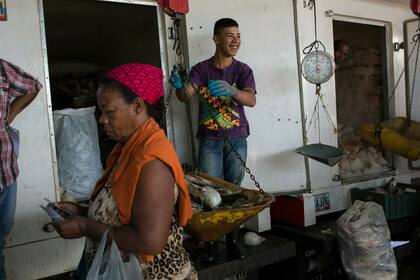 Un trabajador pesa el pescado en un mercado de alimentos en Caracas