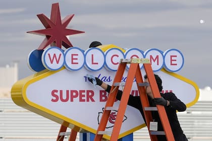 Un trabajador prepara un letrero en Las Vegas, previo a la llegada de los Chiefs de Kansas City y los 49ers de San Francisco para el Super Bowl LVIII