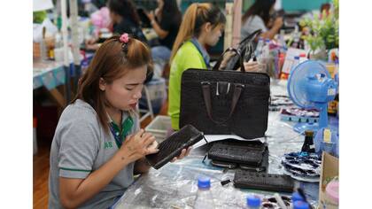 Un trabajador pule una billetera hecha en la granja de cocodrilos Sri Ayuthaya