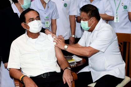 Un trabajador sanitario administra una segunda dosis de la vacuna de AstraZeneca contra el COVID-19 al primer ministro de Tailandia