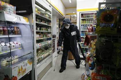 Un trabajador sanitario desinfecta un supermercado en Seúl, la capital de Corea del Sur