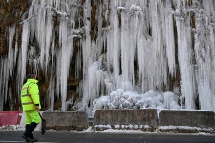 Un trabajador vial observa las rocas congeladas al lado de la ruta al norte de España