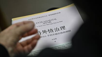 Un trabajo sobre adulterio sostenido por un participante en una consulta con el consejero matrimonial Zhu Shenyong