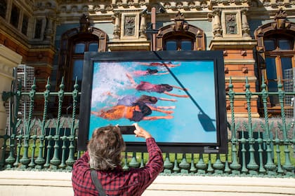 Un transeúnte fotografía la imagen de Patricia Ackerman, "El agua sueña"