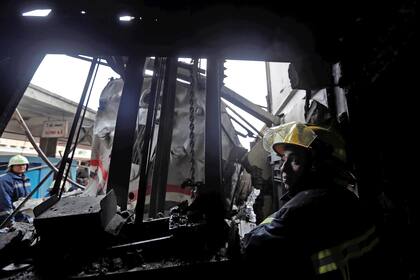 Un bombero trabaja entre los hierros retorcidos del tren