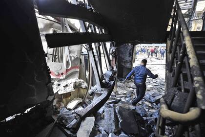 Un hombre camina sobre los escombros de un parte de la estación que colapsó a causa del fuego