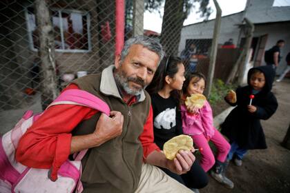 Un vecino lleva a sus hijos a las ollas organizadas por el Club Social y Deportivo "El Rayo"