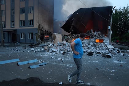 Un vecino reacciona al pasar junto a restos humeantes tras un ataque ruso con drones y misiles en Kiev, Ucrania, el martes 10 de junio de 2025. (AP Foto/Efrem Lukatsky)