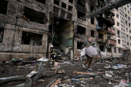 Un vecino recoge sus pertenencias en un bloque de apartamentos atacado por artillería en Kiev, Ucrania, el lunes 14 de marzo de 2022. (AP Foto/Vadim Ghirda)