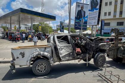 Un vehículo destruido es retirado tras un ataque suicida en un control de carretera cerca del aeropuerto en Mogadiscio, en mayo pasado, en otro atentado de comandos terroristas de Al Shabab (Archivo).