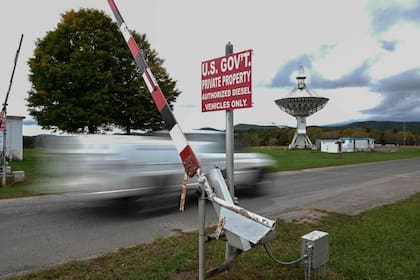 Un vehículo perteneciente al gobierno de los Estados Unidos que funciona con un motor diésel, pasa por una puerta con letreros de advertencia cerca de un telescopio de 45 pies en el Observatorio Green Bank en Green Bank, Virginia Occidental