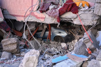 Un vehículo sepultado entre los escombros provocados por el terremoto, a 10 de septiembre de 2023, en Moulay Brahim, provincia de Al Haouz 