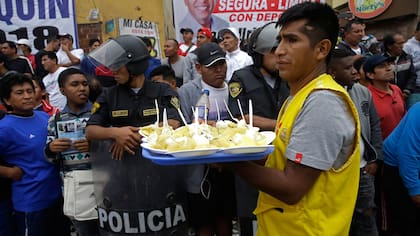 Un vendedor de comida aprovecha un intervalo durante campeonato de fútbol callejero Mundialito de El Porvenir en Lima, Perú.