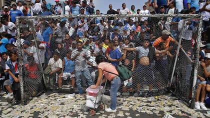 Un vendedor de gelatina aprovecha una pausa en el campeonato de fútbol callejero el Porvenir en Lima, Perú