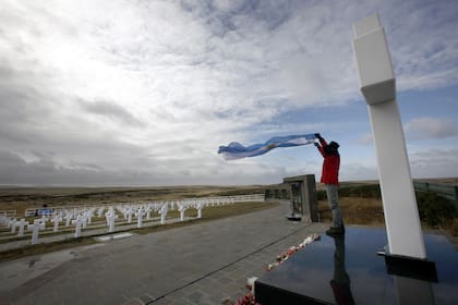 Un veterano de Malvinas ondea la bandera argentina en el cementerio de Darwin, donde yacen más de 200 soldados, en 2012