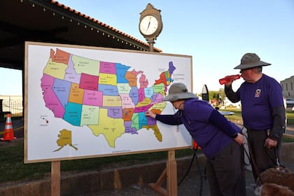 Un visitante agrega un marcador a un mapa que muestra desde dónde visitan los buscadores de eclipses durante la celebración de la ciudad del eclipse solar del 8 de abril en Russellville, Arkansas.