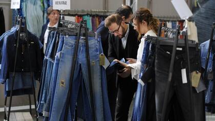 Un visitante de la feria Denim Premiere Vision examina una muestra de un jean en el salón de la industrial textil en París