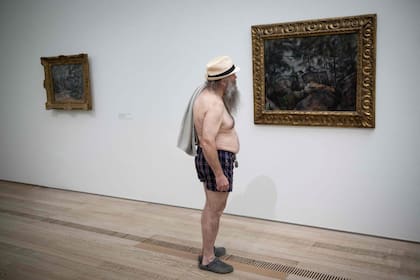 Un visitante en traje de baño observa el cuadro "Rochers a Fontainebleau", de Paul Cezanne