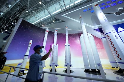 Un visitante toma fotos de réplicas de cohetes espaciales de lanzamiento en la Feria Aérea China de 2021 en Zhuhai 