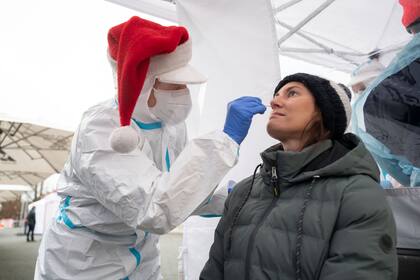 Un voluntario de la Cruz Roja alemana vestido de Papá Noel realiza un hisopado en un centro de testeos rápidos